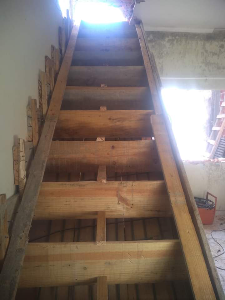 Estrutura de escada de madeira em construção no interior da obra